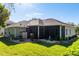 Home featuring a large screened-in patio and beautiful landscaping in the backyard at 3696 Peacepipe Ct, Clermont, FL 34711