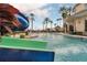 Resort-style pool featuring a water slide and zero entry access surrounded by palm trees at 3850 Eagle Isle Cir, Kissimmee, FL 34746