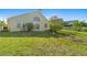 View of the home's backyard and rear exterior, featuring mature landscaping and lake views at 4916 Cedarstone Lane, Orlando, FL 32822