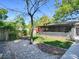 Backyard with green grass, mature trees, lush gardens, and a covered patio for outdoor enjoyment at 500 E Crystal Lake St, Orlando, FL 32806