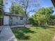 Lush backyard with green grass, a charming building with unique mural, and stone landscaping at 500 E Crystal Lake St, Orlando, FL 32806