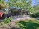 Spacious backyard featuring a screened patio, manicured lawn, mature trees, and lush landscaping at 500 E Crystal Lake St, Orlando, FL 32806