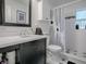 Well-lit bathroom featuring modern vanity with sink, toilet, decorative shower curtain, and black and white tile flooring at 500 E Crystal Lake St, Orlando, FL 32806