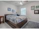 Cozy bedroom featuring a bed with blue and white patterned linens, a ceiling fan, and natural light from the window at 500 E Crystal Lake St, Orlando, FL 32806