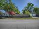 Charming single-story home with a detached garage, lush trees, and blooming bougainvillea at 500 E Crystal Lake St, Orlando, FL 32806