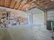 Garage showcasing exposed ceiling beams, block walls, shelving, and an open garage door, with natural light at 500 E Crystal Lake St, Orlando, FL 32806