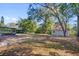 Expansive backyard with mature trees, a storage shed, and a screened-in enclosure perfect for outdoor activities at 5325 Glasgow Ave, Orlando, FL 32819