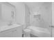 A well-lit bathroom features a tiled shower-tub, modern vanity, toilet and sleek finishes at 5325 Glasgow Ave, Orlando, FL 32819