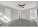 A bright bedroom features modern flooring and a stylish ceiling fan, plus attached bathroom access at 5325 Glasgow Ave, Orlando, FL 32819