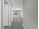 Hallway with gray wood floors and a view of the front door and backyard at 5325 Glasgow Ave, Orlando, FL 32819
