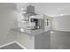 Modern kitchen features stainless steel appliances, a breakfast bar, and gray wood floors at 5325 Glasgow Ave, Orlando, FL 32819