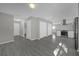 Open-concept living room with gray wood floors, neutral walls, and a view of the modern kitchen at 5325 Glasgow Ave, Orlando, FL 32819
