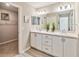 Bathroom featuring double sinks, white cabinets, and a walk-in closet at 5996 Wildflower Field Way, St Cloud, FL 34771