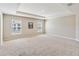 Spacious bedroom with tray ceiling, carpeted floors, and natural light from windows at 5996 Wildflower Field Way, St Cloud, FL 34771