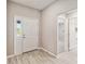 Bright foyer with light wood-look floors, white trim and a front door with sidelight at 5996 Wildflower Field Way, St Cloud, FL 34771