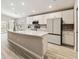 Modern kitchen features an island, stainless steel appliances, white cabinets, and light wood-look floors at 5996 Wildflower Field Way, St Cloud, FL 34771