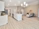 Open-concept kitchen with a large island, stainless steel appliances, and modern lighting at 5996 Wildflower Field Way, St Cloud, FL 34771