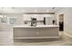 Bright kitchen features a large island with white countertop, stainless steel appliances and white cabinets at 5996 Wildflower Field Way, St Cloud, FL 34771