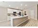 Updated kitchen featuring an island, stainless steel appliances, white cabinets, and updated flooring at 5996 Wildflower Field Way, St Cloud, FL 34771