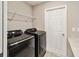Laundry room with modern washer and dryer, complemented by ample storage space at 5996 Wildflower Field Way, St Cloud, FL 34771