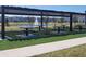 Outdoor picnic area with a shaded pergola and tables overlooking a pond with a fountain in a community at 5996 Wildflower Field Way, St Cloud, FL 34771