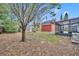 Large backyard featuring a large tree, a red shed, and a screened-in porch at 6373 Forecastle Ct, Orlando, FL 32807