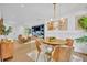 Cozy dining area adjacent to living room, complete with round table, stylish chairs, and chic chandelier at 6373 Forecastle Ct, Orlando, FL 32807