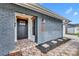Inviting front entrance featuring a stylish gray brick facade, modern door, and decorative house number display at 6373 Forecastle Ct, Orlando, FL 32807