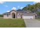 Inviting single-story home with attached two-car garage, well-maintained landscaping, and a classic architectural design at 68 Herring Ct, Kissimmee, FL 34759
