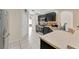 Galley kitchen featuring modern stainless steel appliances, dark cabinetry, tile floors and plenty of counter space at 68 Herring Ct, Kissimmee, FL 34759