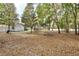 A sprawling backyard featuring mature trees and a fire pit, perfect for outdoor gatherings at 8176 Emerald Forest Ct, Sanford, FL 32771