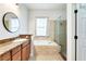 Bathroom with granite vanity, built-in tub, and glass-enclosed shower for a relaxing experience at 8176 Emerald Forest Ct, Sanford, FL 32771