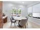 Bright breakfast nook featuring a view of the pool, neutral chairs, and light-filtering shades at 8176 Emerald Forest Ct, Sanford, FL 32771