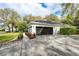 A two car garage exterior is surrounded by landscaping and a long driveway at 8176 Emerald Forest Ct, Sanford, FL 32771