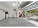 Spacious garage with epoxy floor, storage, and an open door showcasing the home's exterior at 8176 Emerald Forest Ct, Sanford, FL 32771