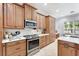 Well-equipped kitchen featuring stainless steel appliances, wooden cabinetry, and white countertops at 8176 Emerald Forest Ct, Sanford, FL 32771