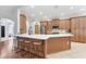 Spacious kitchen island featuring quartz countertops, bar seating, and wood-paneled cabinetry at 8176 Emerald Forest Ct, Sanford, FL 32771