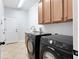 Well-lit laundry room featuring modern washer and dryer units with storage cabinets at 8176 Emerald Forest Ct, Sanford, FL 32771