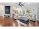 Bright living room features a large sectional sofa, ceiling fan, and hardwood floors at 8176 Emerald Forest Ct, Sanford, FL 32771