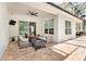 This covered patio features brick floors, ceiling fan, and comfortable seating around a fire pit at 8176 Emerald Forest Ct, Sanford, FL 32771