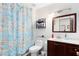 The bathroom has a shower with blue floral curtains, a toilet, a dark vanity, and a mirror at 835 Longleaf Pine Ct, Orlando, FL 32825