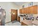This kitchen has a stainless steel refrigerator, a light countertop, wooden cabinets, and tiled floors at 835 Longleaf Pine Ct, Orlando, FL 32825