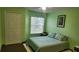 Bright bedroom featuring green walls, a comfortable bed, and a window with natural light at 8837 Latrec Ave # 5307, Orlando, FL 32819