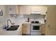 Well-lit kitchen featuring white cabinets, modern appliances, and a sink under the window at 8837 Latrec Ave # 5307, Orlando, FL 32819