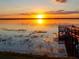 Scenic lake view at sunset with a wooden dock in the foreground at 8837 Latrec Ave # 5307, Orlando, FL 32819