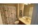 Neutral bathroom featuring a shower tub with colorful floral curtain at 8991 Cuban Palm Rd, Kissimmee, FL 34747