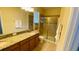 Bathroom featuring double sinks with granite countertops and a glass-enclosed shower at 8991 Cuban Palm Rd, Kissimmee, FL 34747