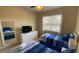 Bright bedroom features twin beds with blue and white bedding, a dresser, TV, and a mirror at 8991 Cuban Palm Rd, Kissimmee, FL 34747