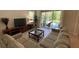 Cozy living room with neutral decor, large windows, and sliding glass doors leading to the patio at 8991 Cuban Palm Rd, Kissimmee, FL 34747