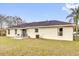 Exterior view of the home featuring a well-maintained backyard with a patio and lush green grass at 96 Pecan Dr, Ocala, FL 34472
